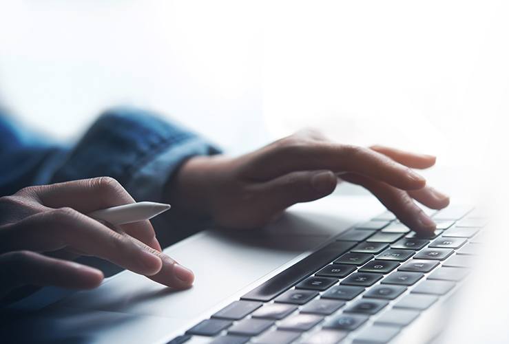 Close up of person typing on a keyboard