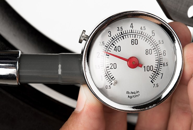 hand of a man holding tyre pressure gauge