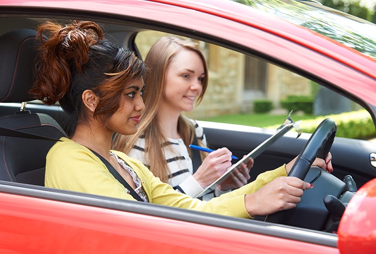 Driver on a lesson with instructor holding clipboard