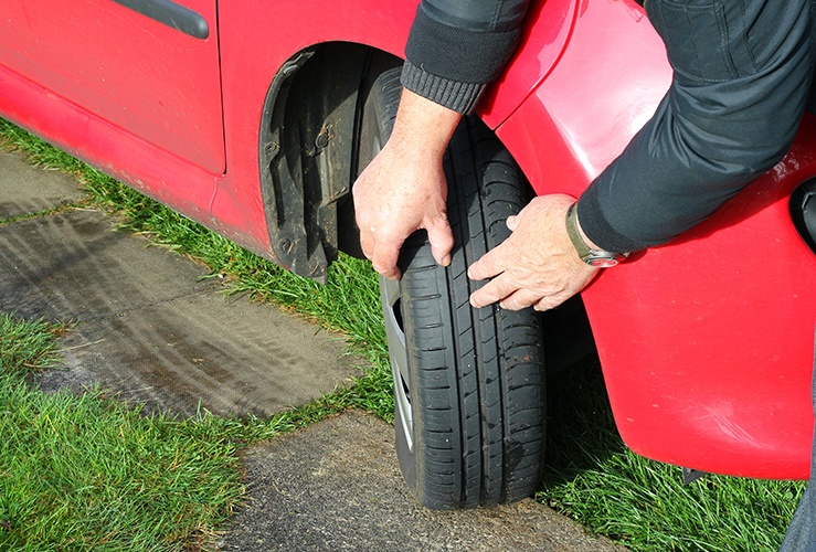 Person checking tyre tread 