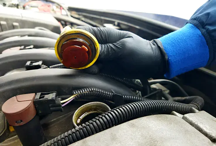 A mechanic checking the coolant in an engine