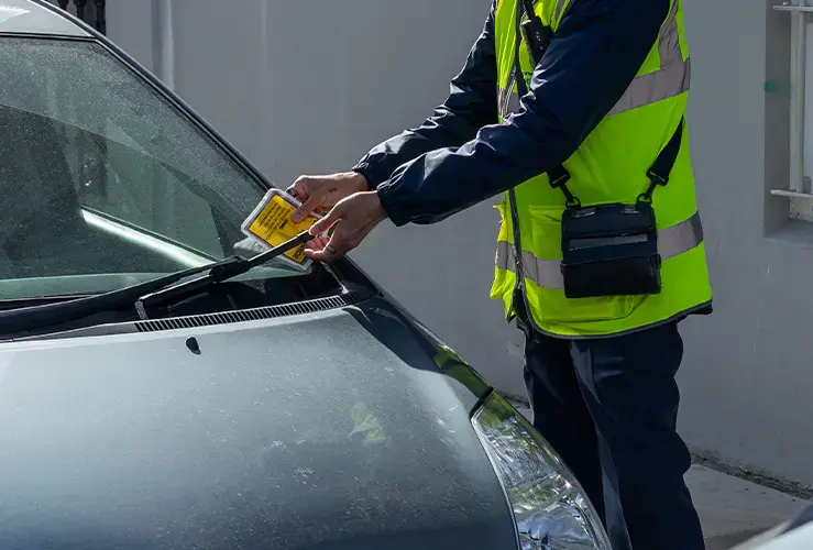 An official putting a fine on a car