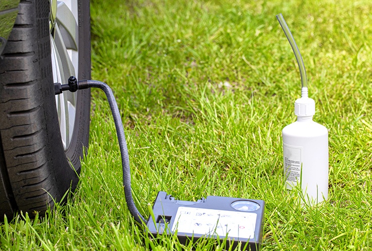 Car tyre next to a car sealant kit